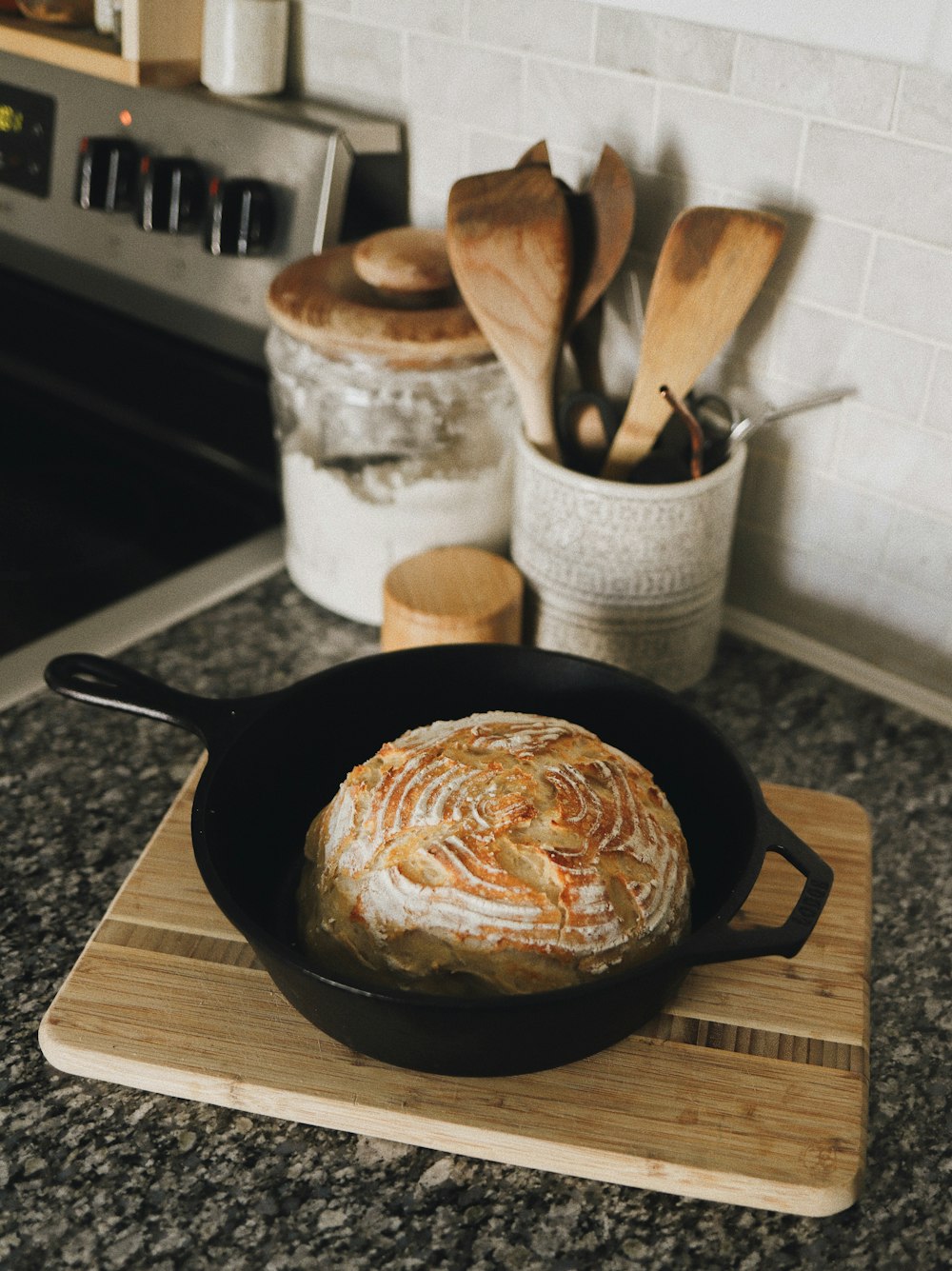 a skillet with a loaf of bread in it on a cutting board