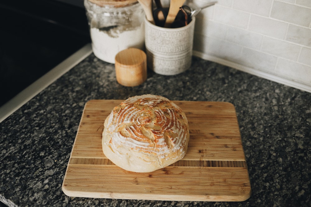 a loaf of bread sitting on top of a wooden cutting board