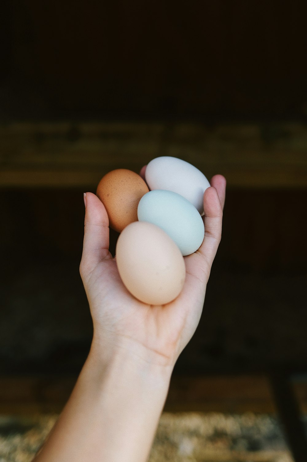 a person holding three eggs in their hand