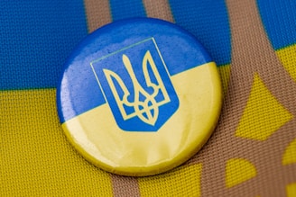 a blue and yellow button sitting on top of a table