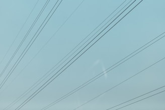 a blue sky with power lines in the foreground