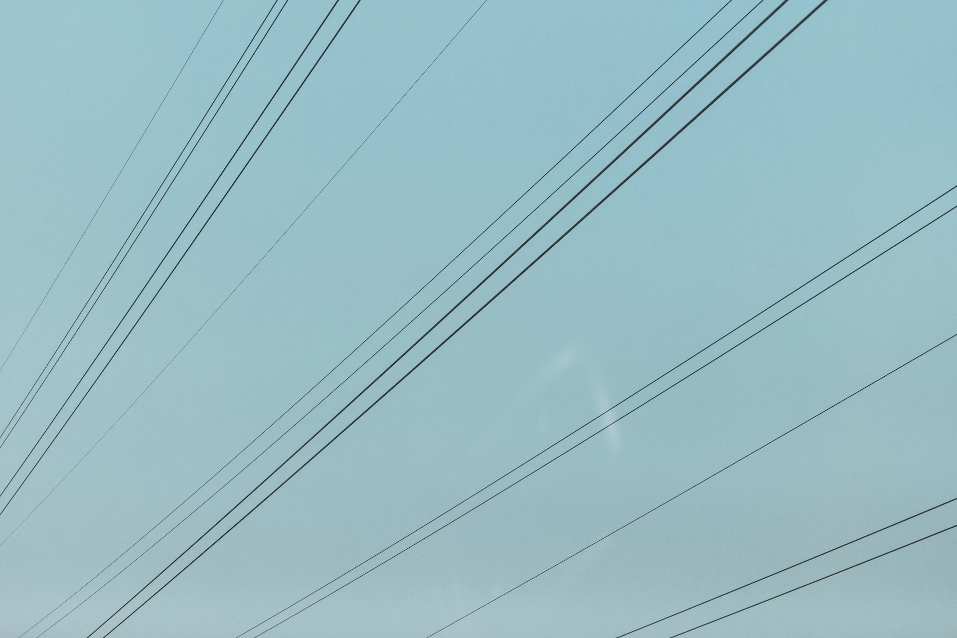 a blue sky with power lines in the foreground