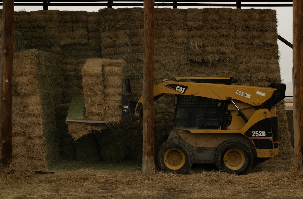 a tractor parked next to a pile of hay