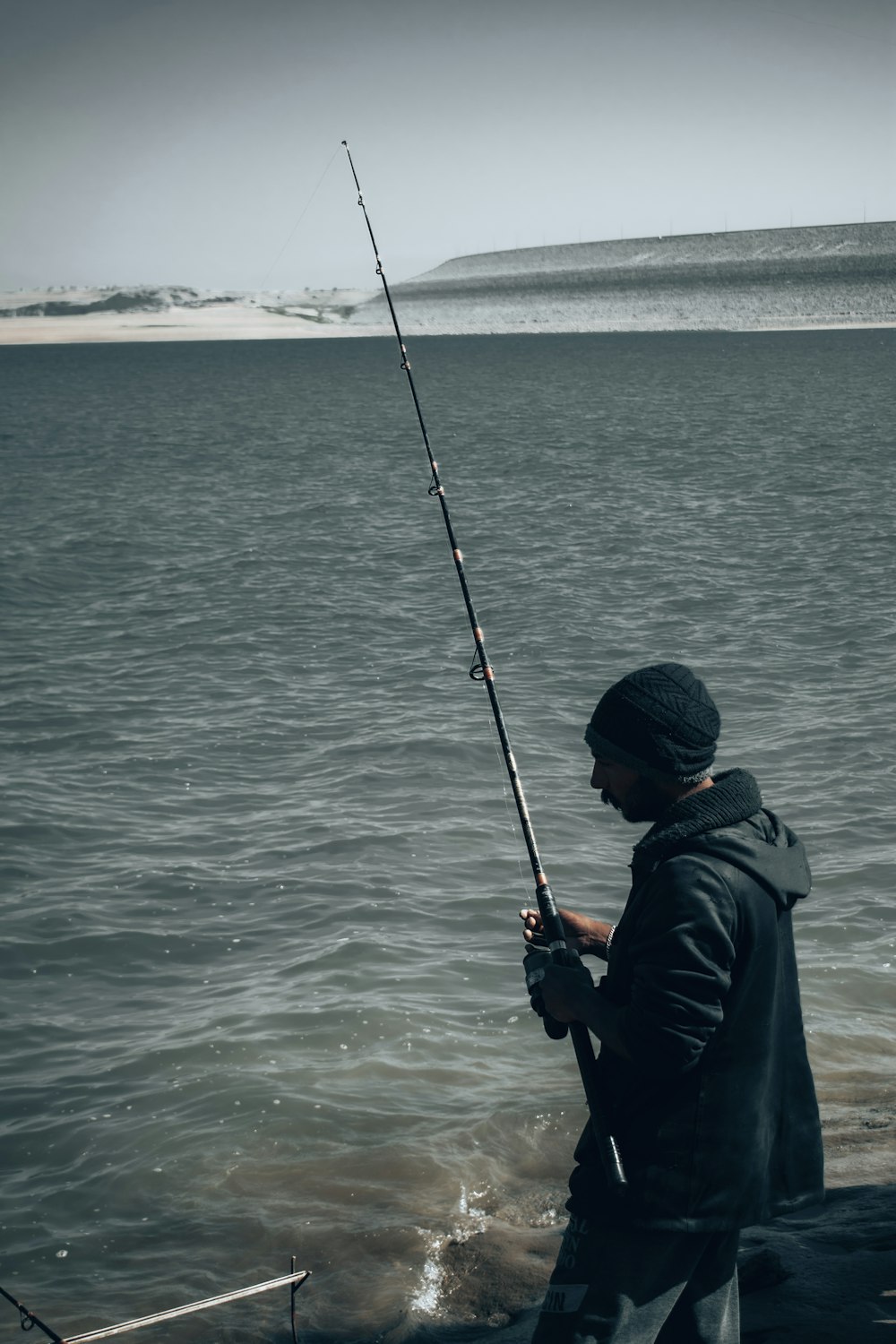 a man standing on a boat holding a fishing pole