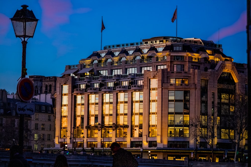 a tall building with lots of windows and a street light in front of it