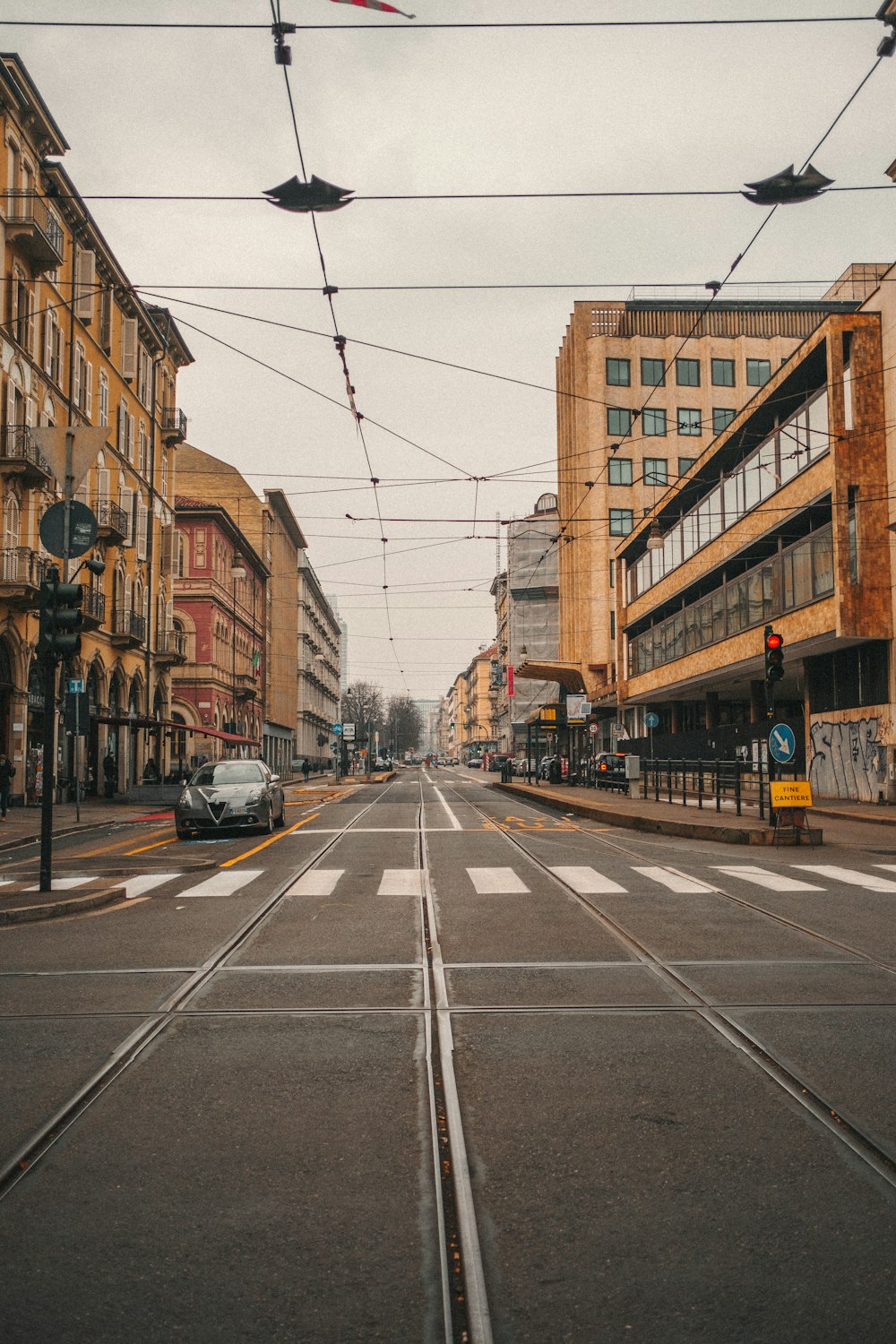 Una strada cittadina con alcune auto che la percorrono