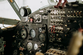 A close-up of a propeller plane’s cockpit, showcasing detailed instruments and controls.