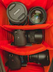 An artistic shot of a camera bag open with various photography gear inside.