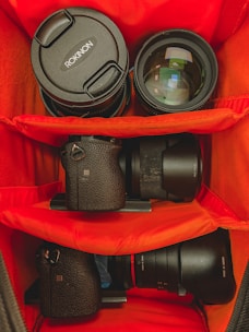 A compact camera bag open to reveal organized compartments filled with photography gear.