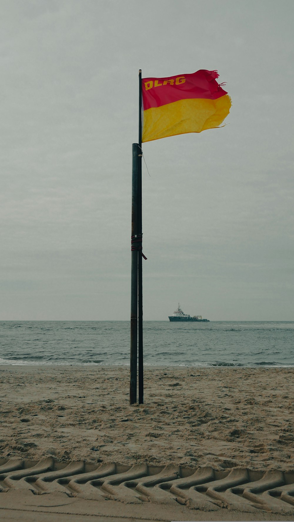 a flag on a pole on a beach
