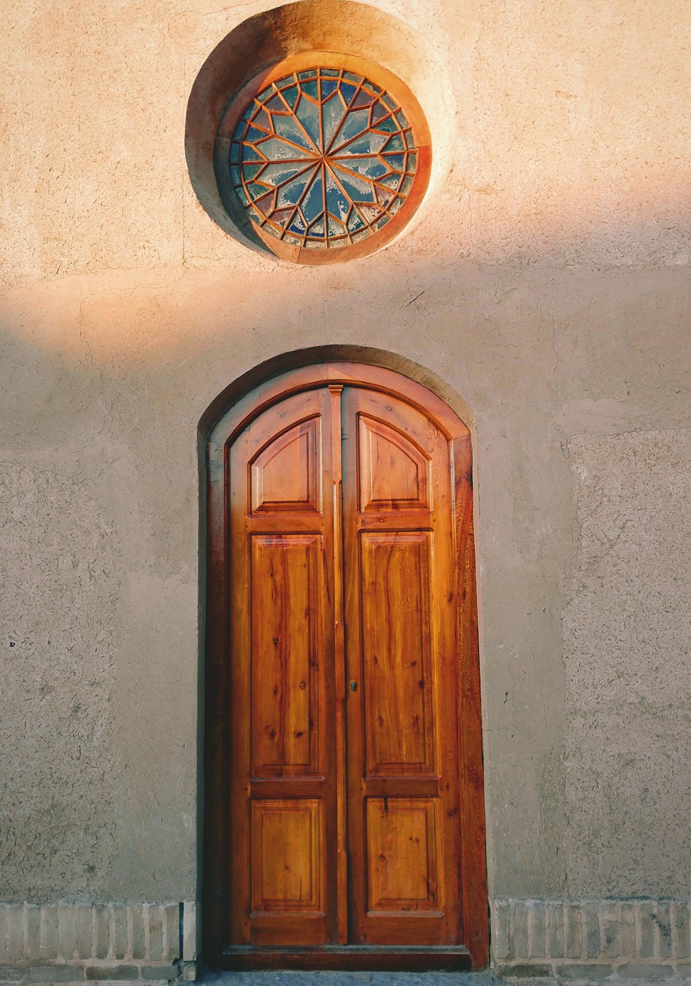 a wooden door with a circular window above it