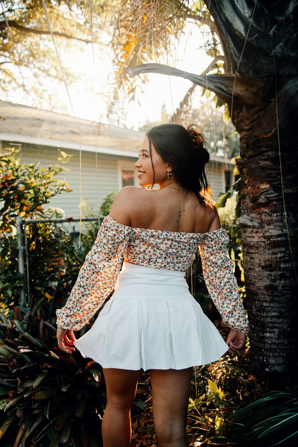 a woman wearing a white skirt and off the shoulder top