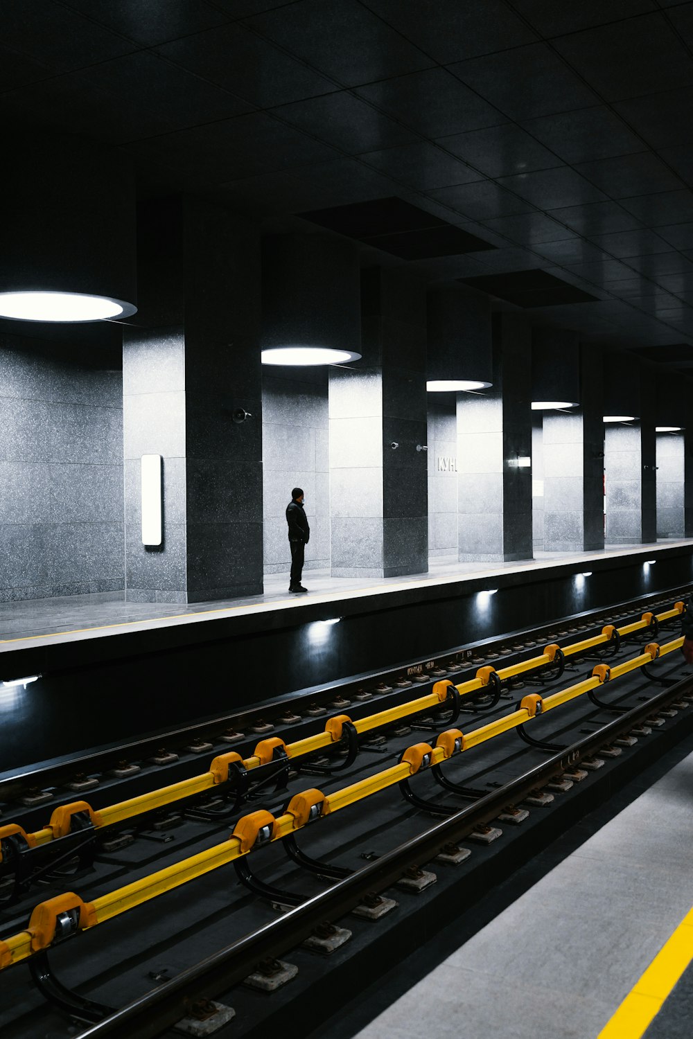 a train station with a person standing on the platform