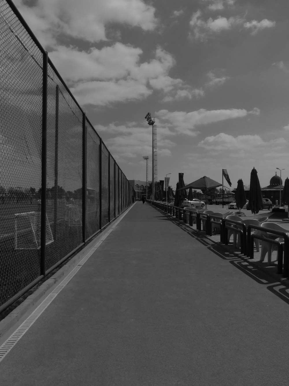 a row of benches sitting next to a fence