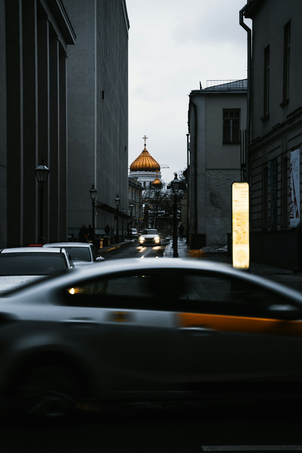 a car driving down a street next to tall buildings