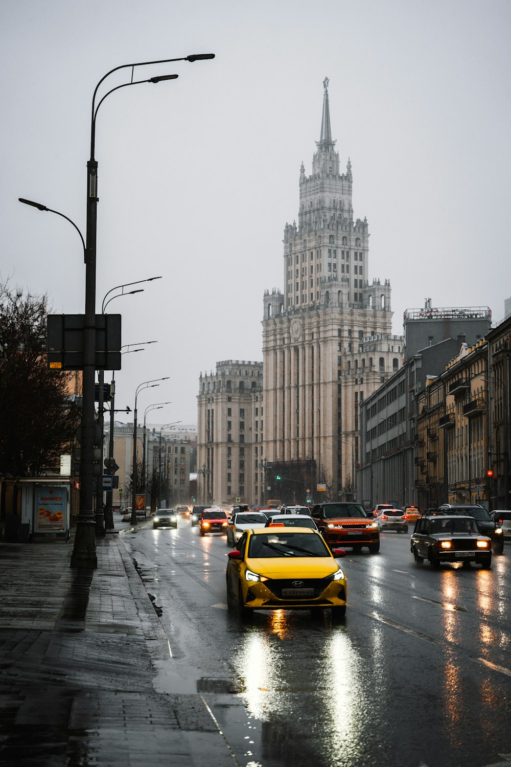 a city street filled with lots of traffic next to tall buildings