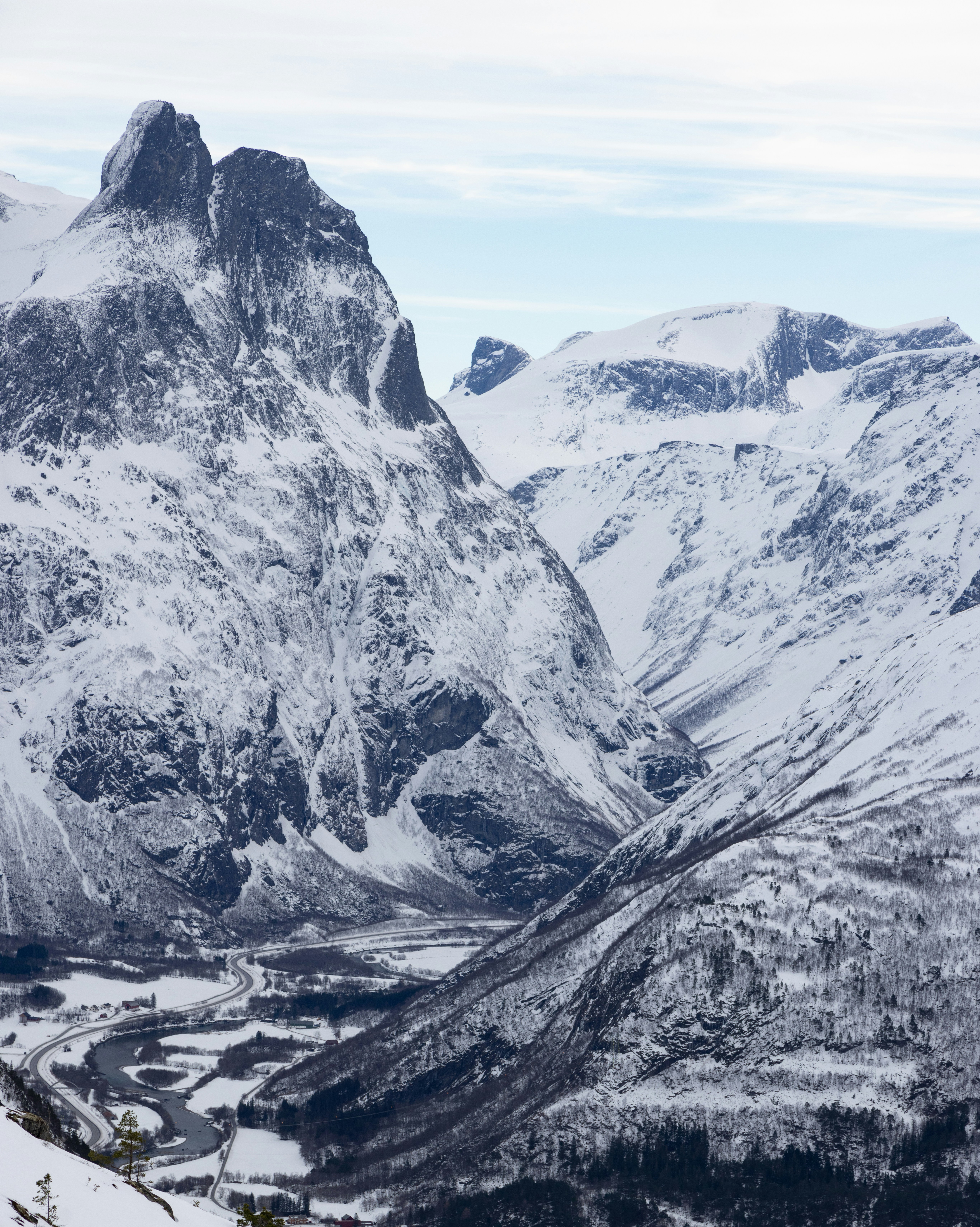a snowy mountain range with a valley below
