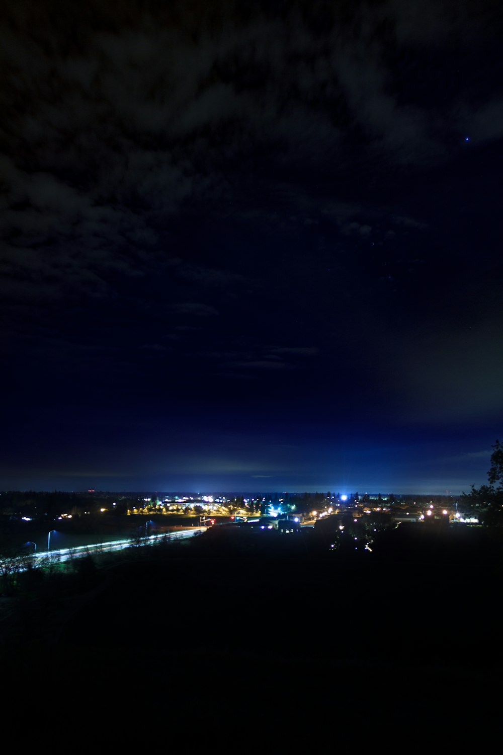uma vista de uma cidade à noite do topo de uma colina