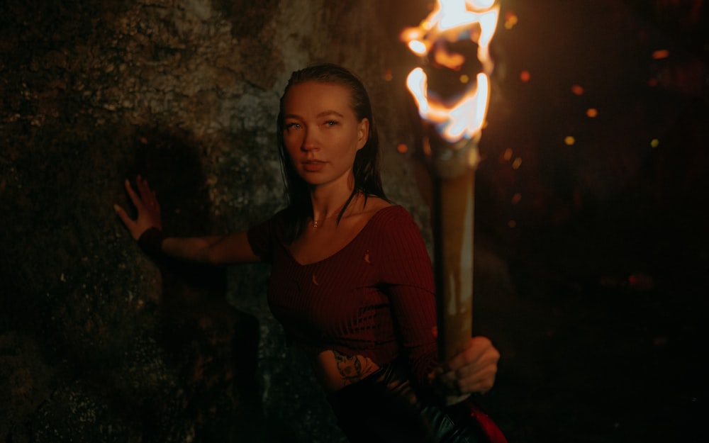 a woman holding a torch in a cave