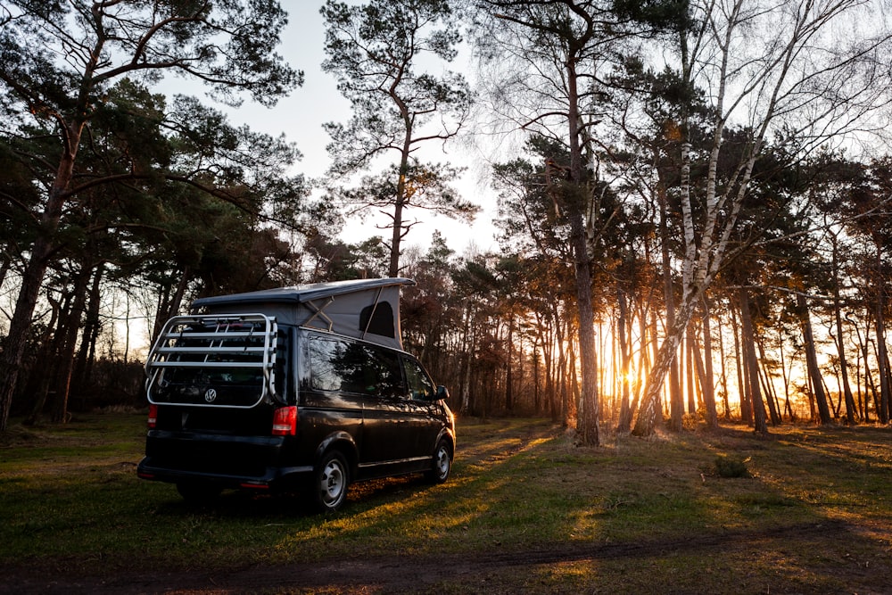 a van is parked in the middle of the woods