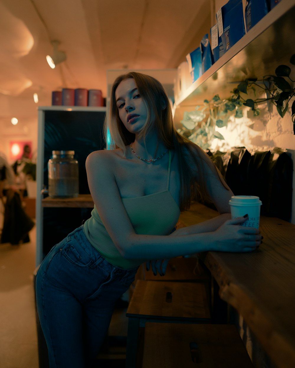 Una mujer sentada en un mostrador con una taza de café