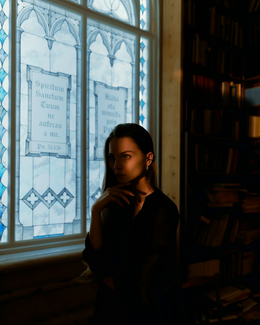 a woman standing in front of a stained glass window