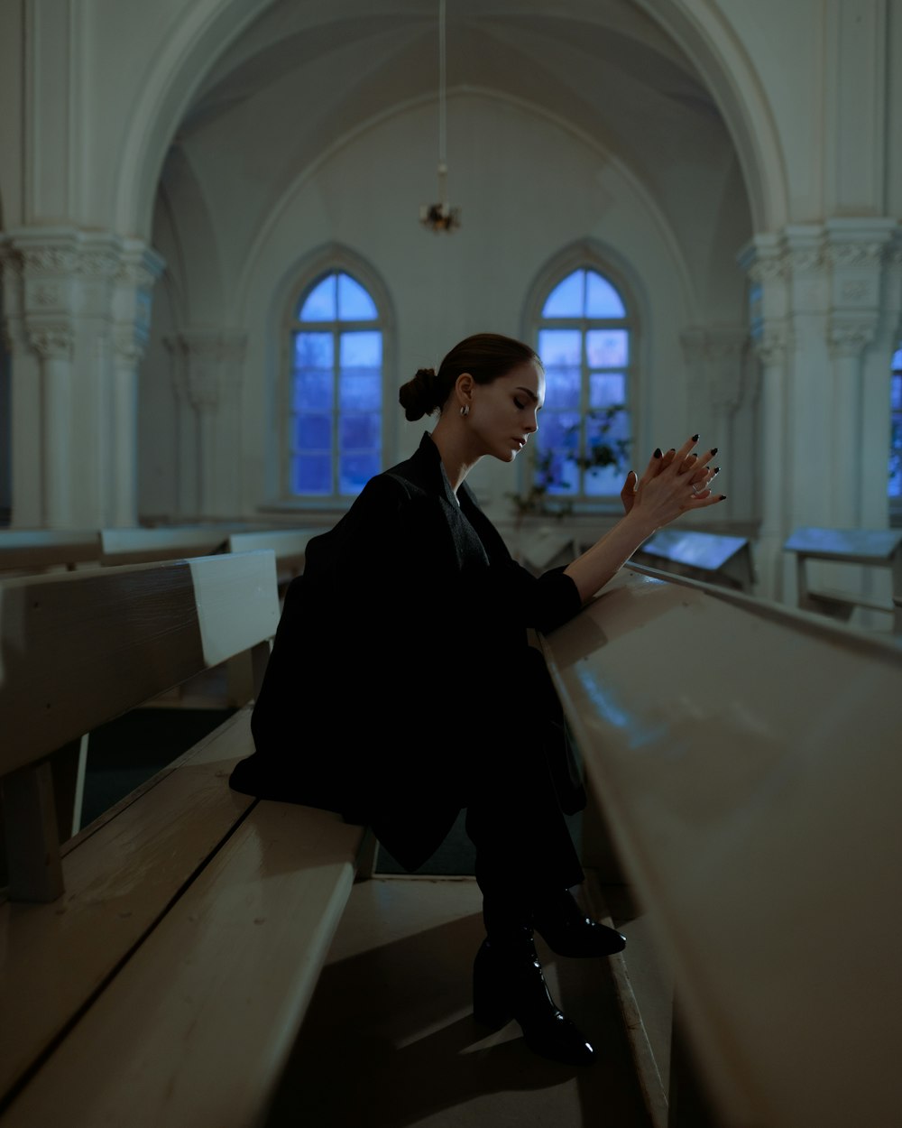 a woman sitting on a bench in a church