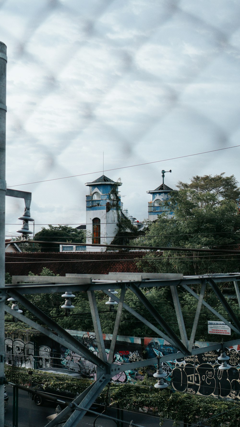 a clock tower on top of a building behind a chain link fence