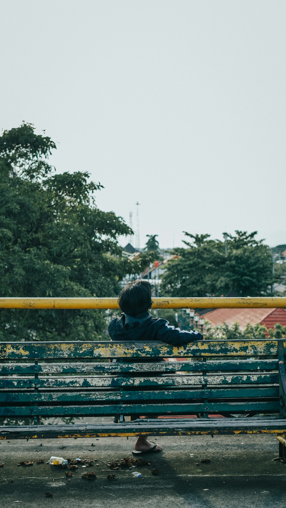 a person sitting on a bench in a park