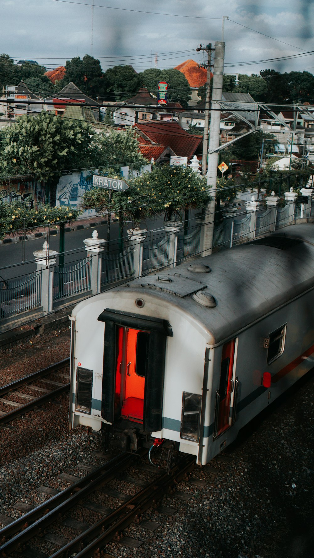 a train traveling down train tracks next to a lush green hillside