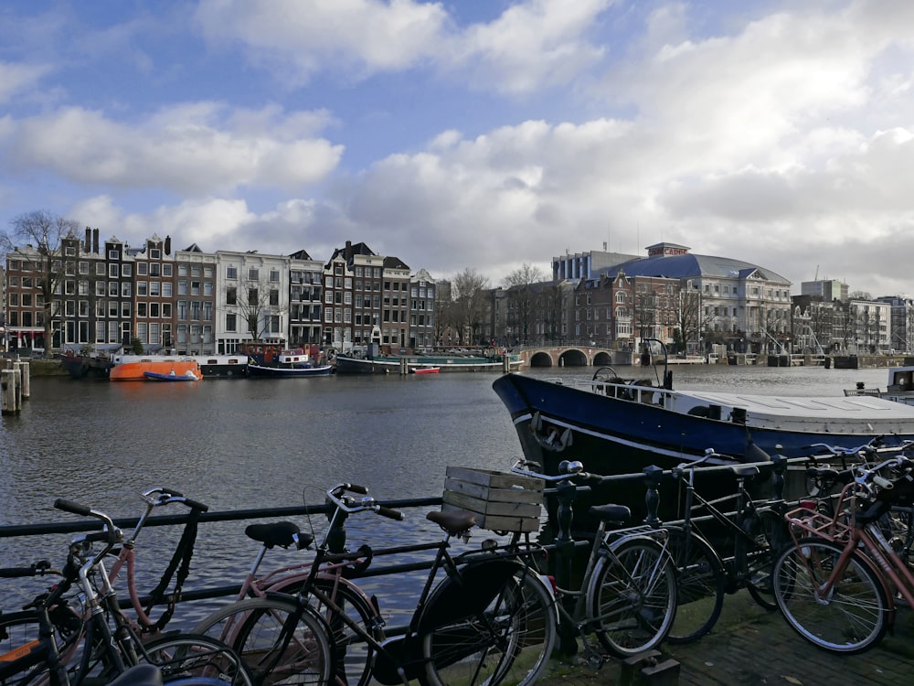 a row of bikes parked next to a body of water