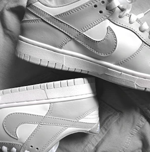 Close-up of a sleek baby blue sneaker with white laces on a soft fabric background