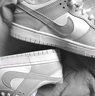Close-up of a sleek baby blue sneaker with white laces on a soft fabric background
