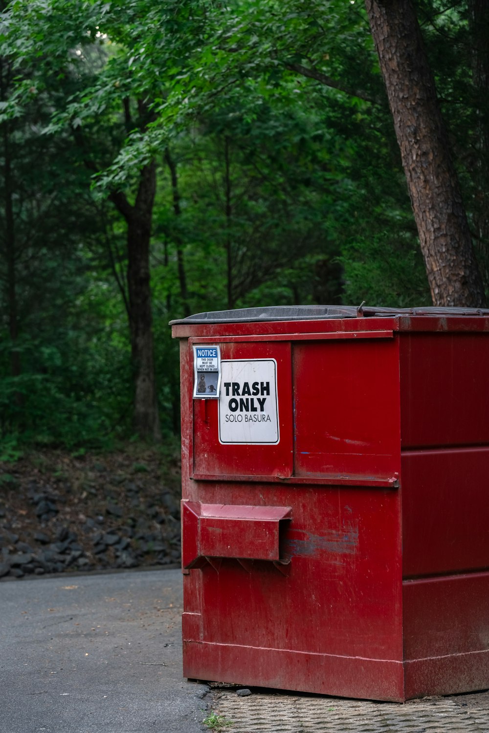 a trash can sitting on the side of a road