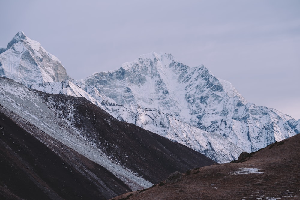 a snow covered mountain with a trail leading to it