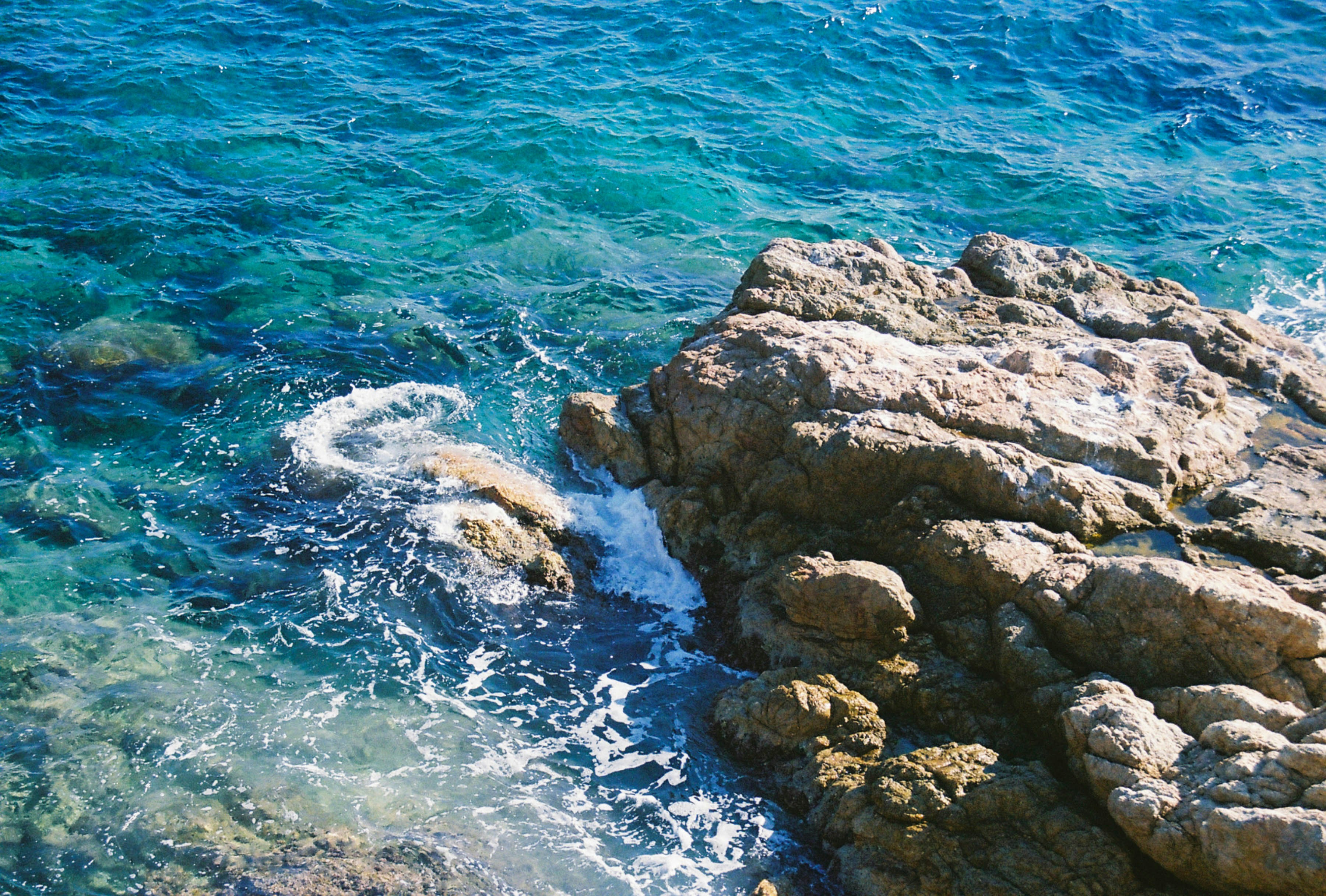 a rocky shore with clear blue water