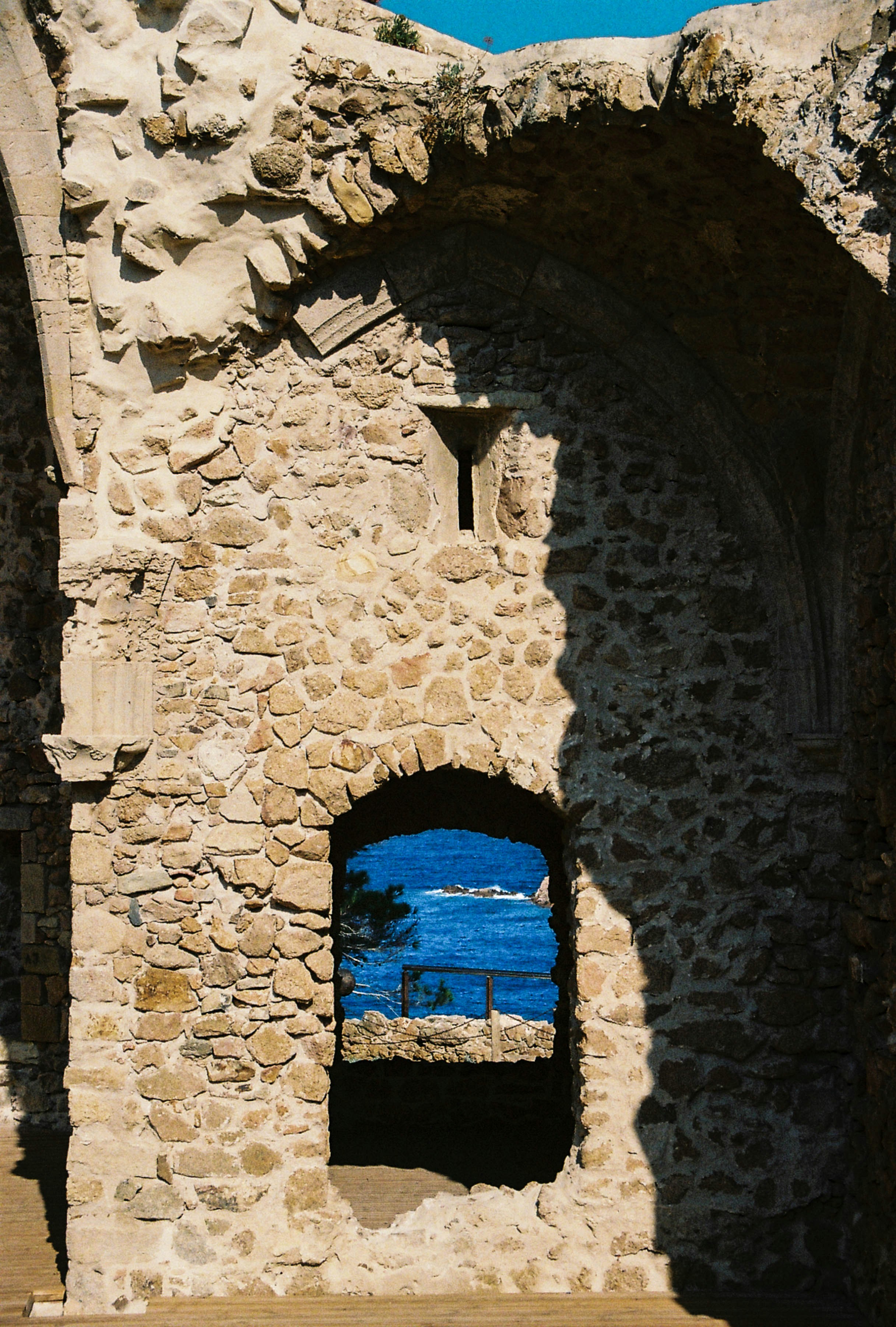 a stone building with a blue window in it
