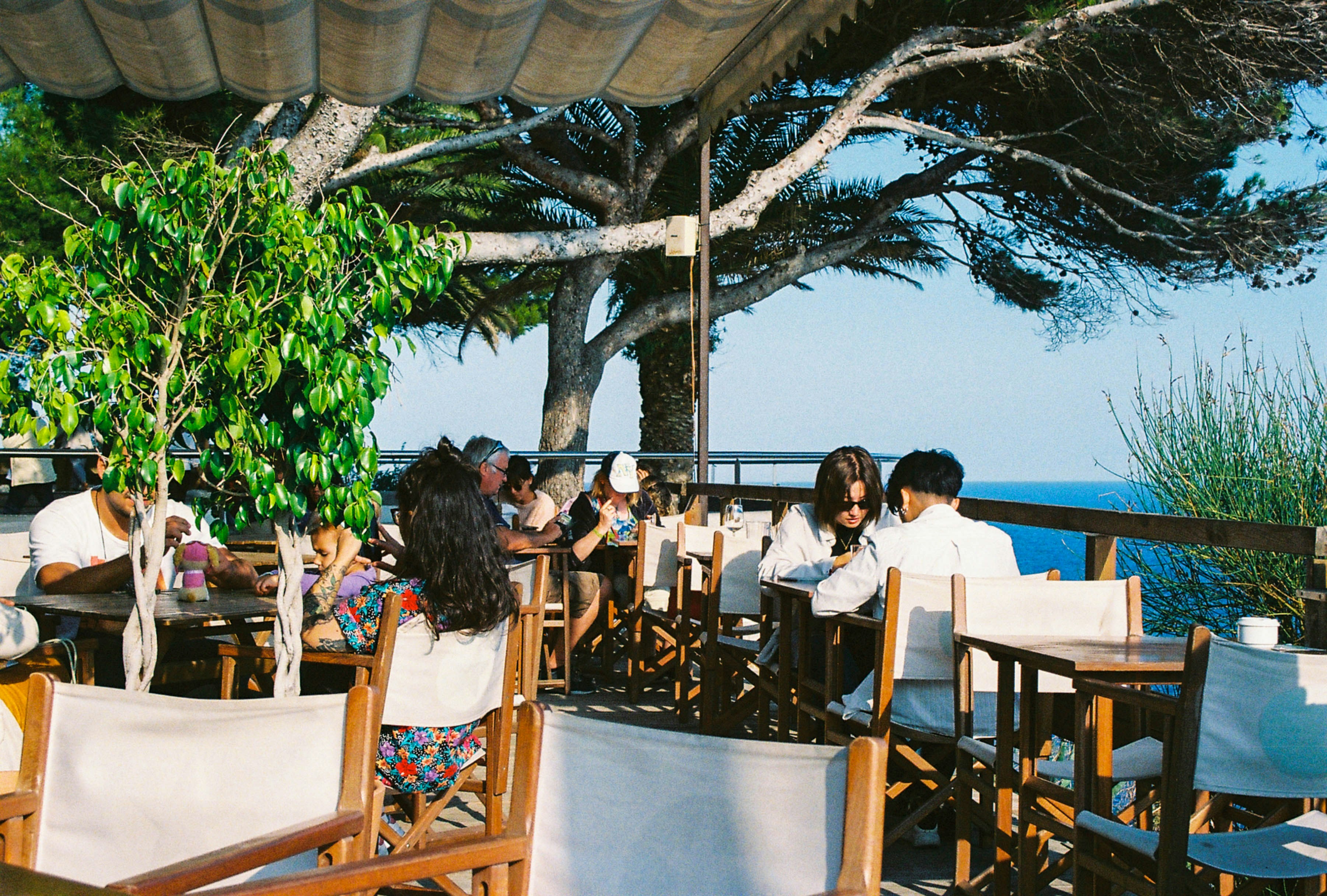 a group of people sitting at wooden tables