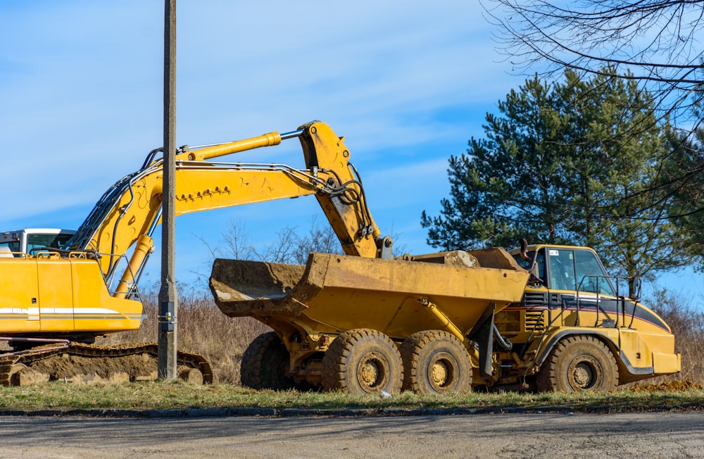 a large yellow truck parked next to a tree