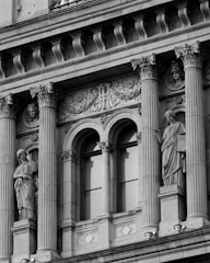 a black and white photo of a building with statues on it