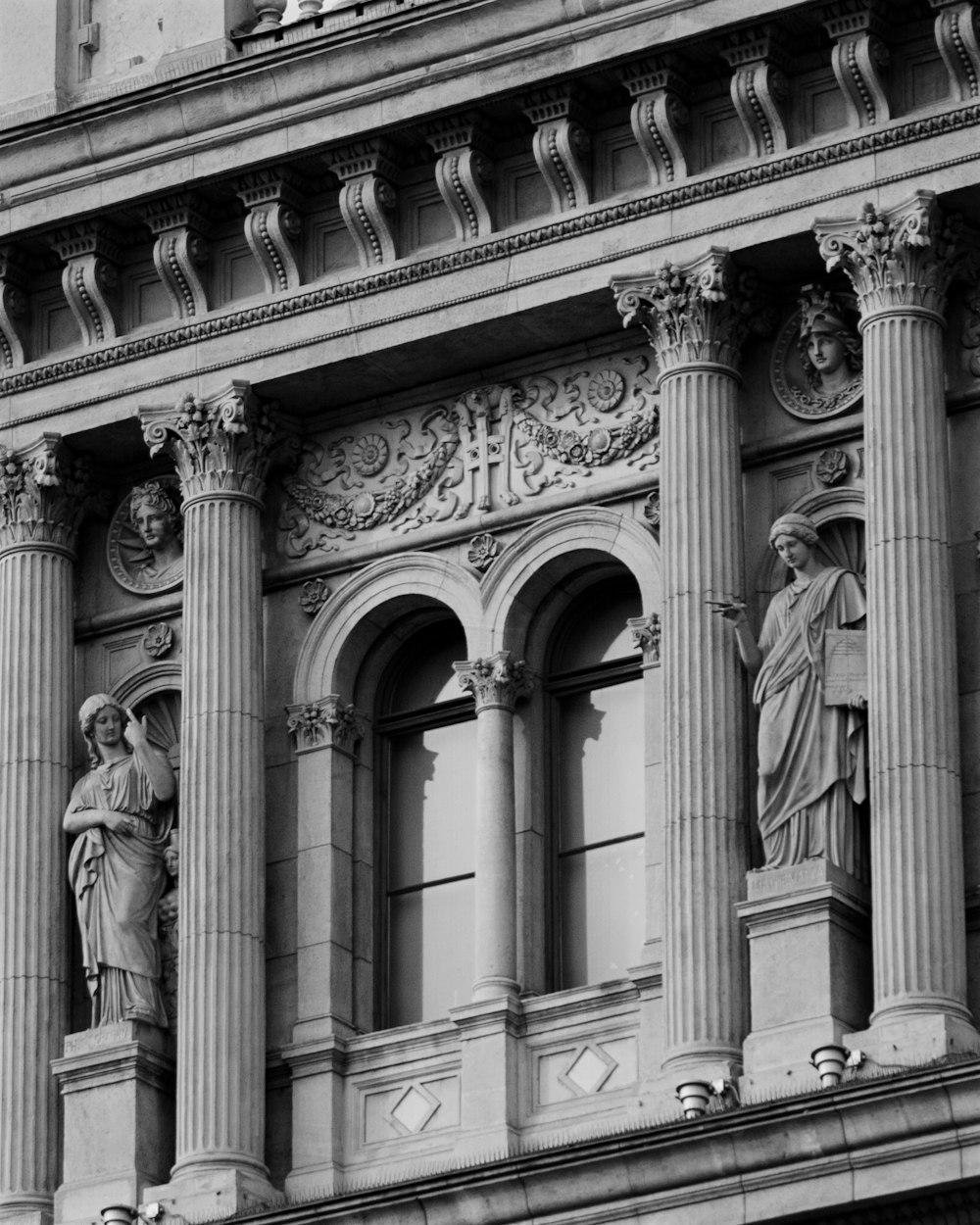 une photo en noir et blanc d’un bâtiment avec des statues dessus