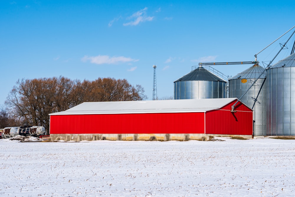 a red barn and silos in a snowy field