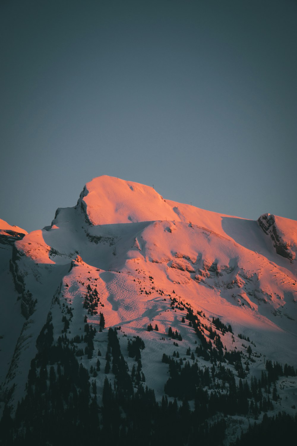 a mountain covered in snow at sunset