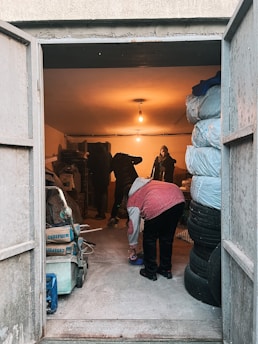 a woman in a garage with a large pile of tires