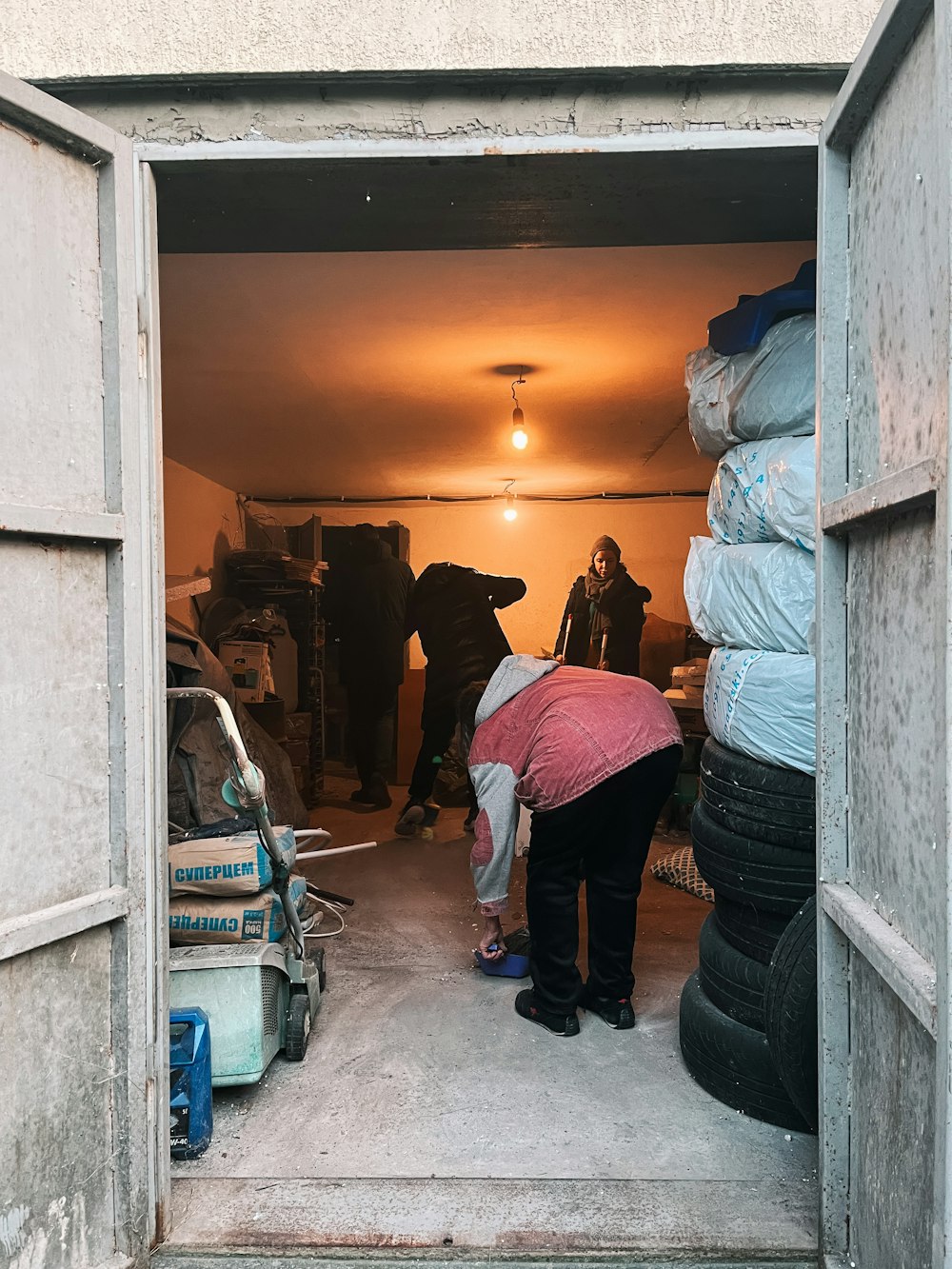 a woman in a garage with a large pile of tires