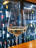 Close-up of a wine glass filled with red wine on a wooden table.