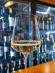 A close-up of a wine bottle and glass on a table.