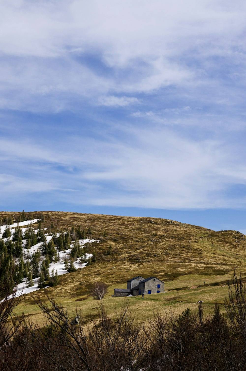 uma casa em uma colina com neve no chão