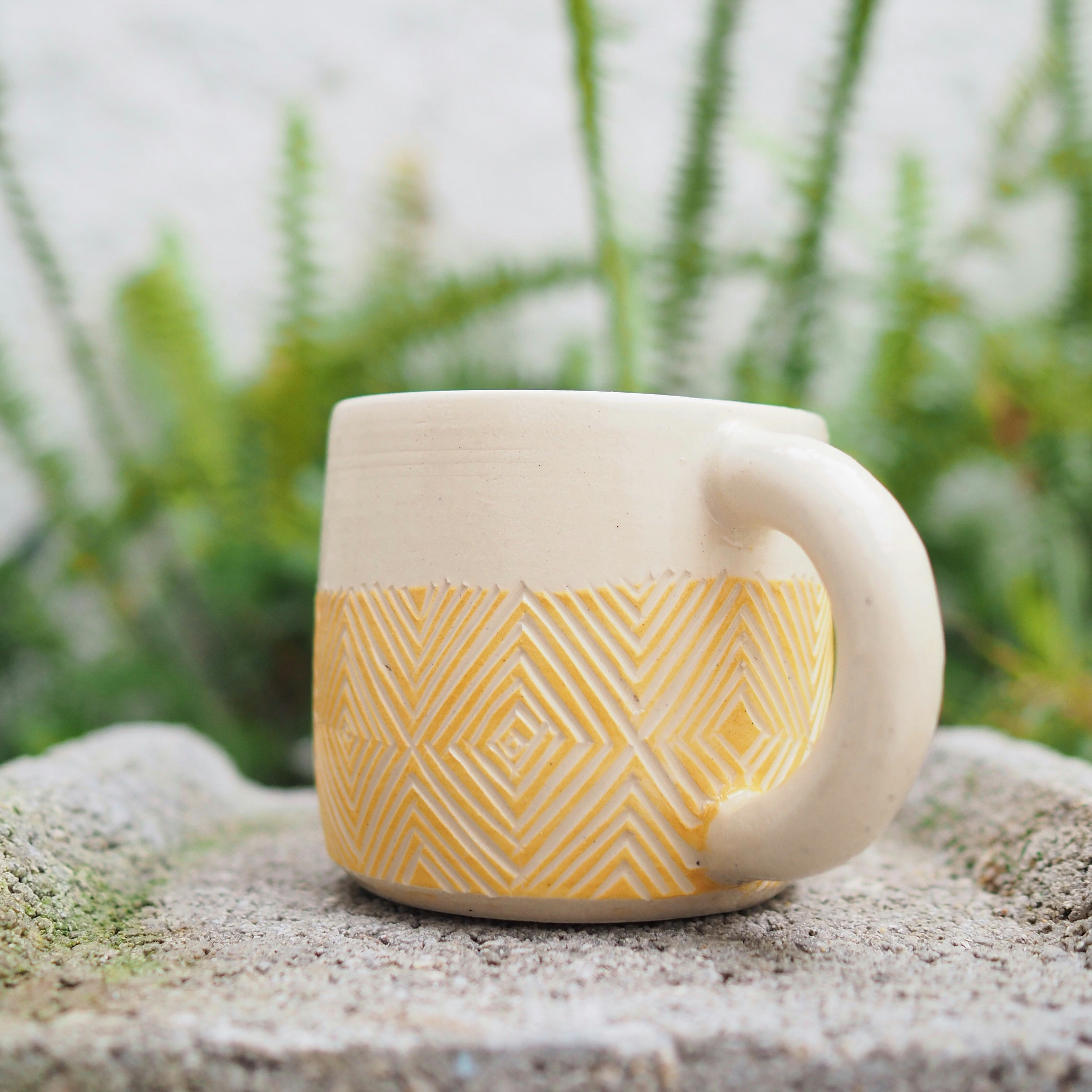 Hand-painted ceramic coffee mug with sunrise pattern in warm orange tones