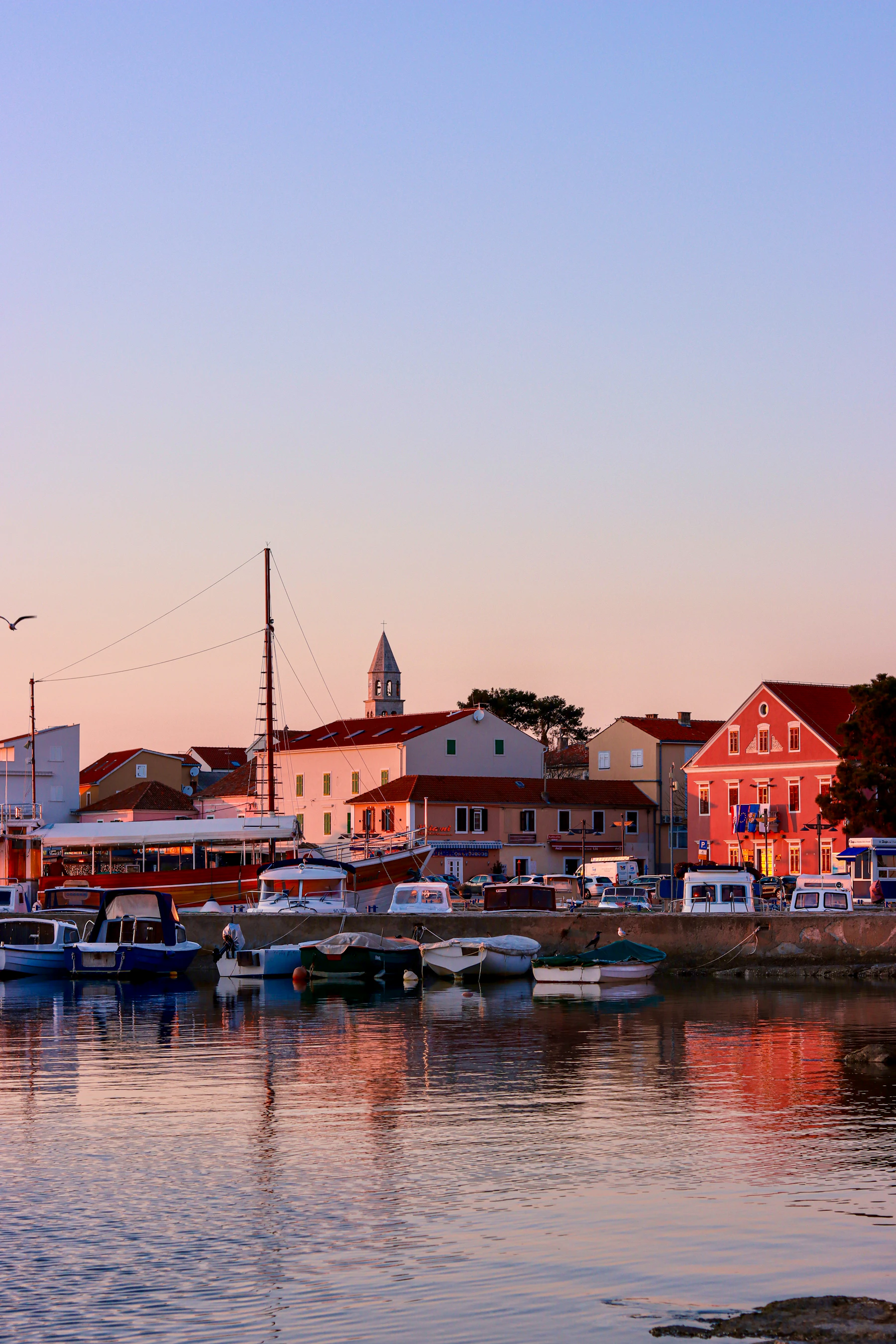 Small boats are moored in a harbour.